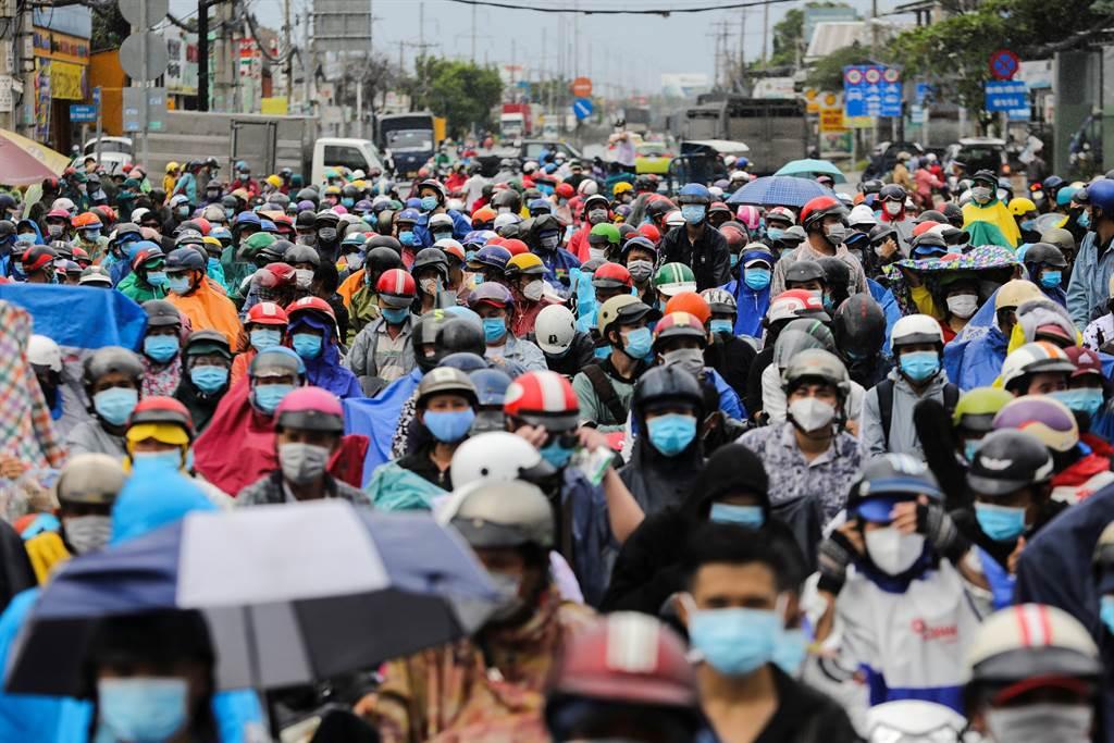 越南胡志明市衛生廳指出，將為全市70萬名年齡介於12至17歲的兒童與青少年施打COVID-19疫苗。圖為移工在檢查站等候要離開胡志明市的一景。（圖／路透）
