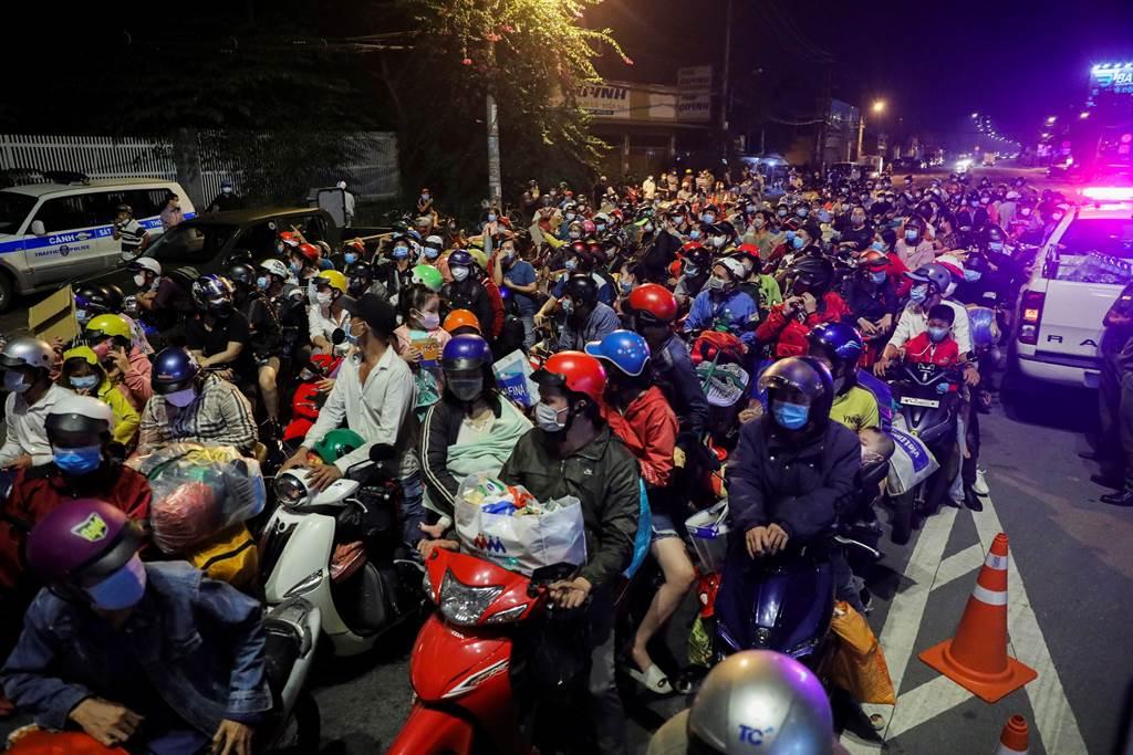 大量工人騎車要離開疫情嚴重的越南胡志明市。（圖／路透）