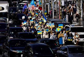 日本民眾戴著口罩，參加於東京的支持烏克蘭遊行。（圖／路透社）