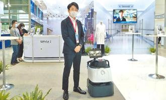 台灣愛麗思歐雅瑪總經理山本翔在2022智慧城市展攤位中，展示所引進的DX清掃機器人Whiz i IRIS EDITION。圖／黃志偉