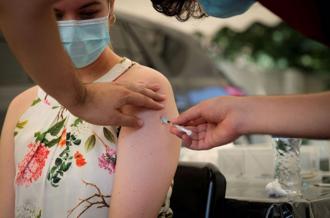 約翰尼斯堡Omicron傳播期間，一名醫護人員為一名婦女接種冠狀病毒疾病（COVID-19）疫苗資料照。（路透社）