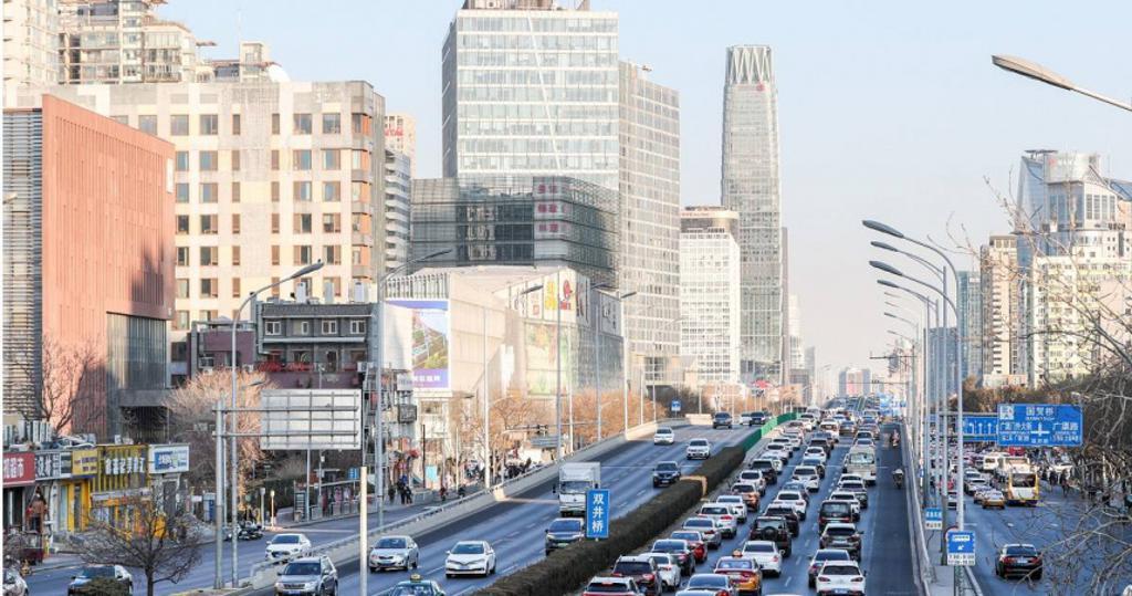 中國大陸近期消費人潮湧入各賣場，8日並重新開放邊境，圖為今年元旦北京國貿地區車流集中。（圖／中新社）