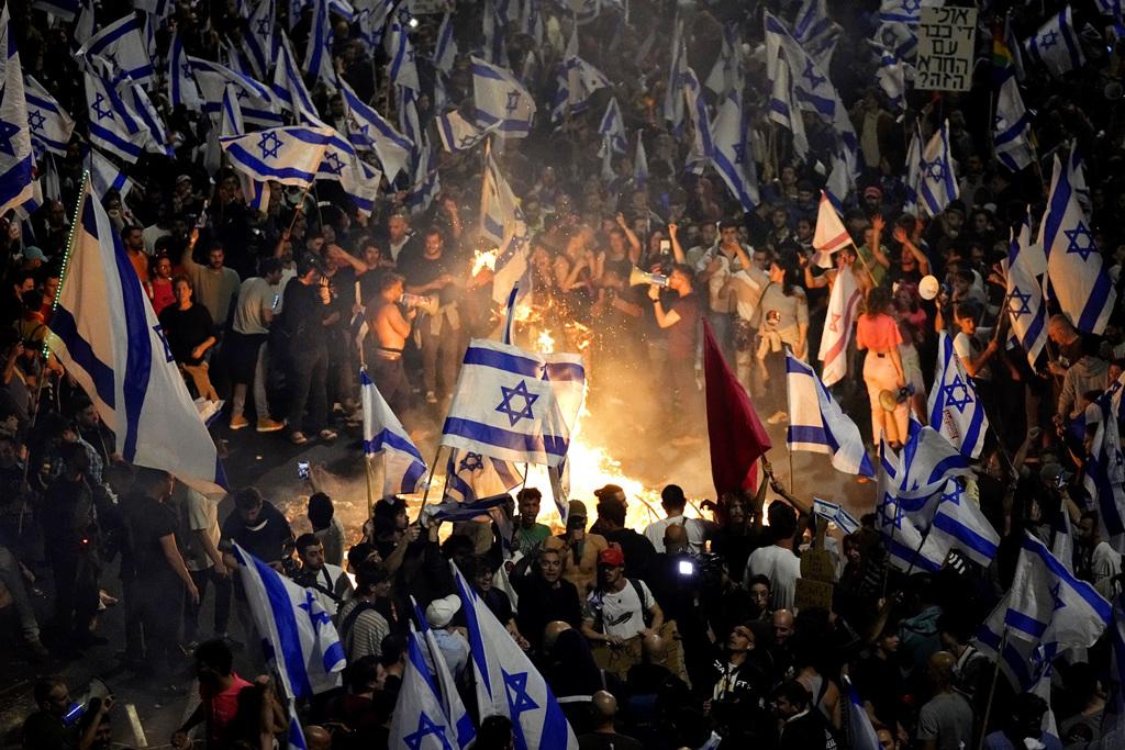 上萬以色列人26日深夜霸占特拉維夫一座高速公路抗議，在公路上燃燒廢棄物。（圖／美聯社）