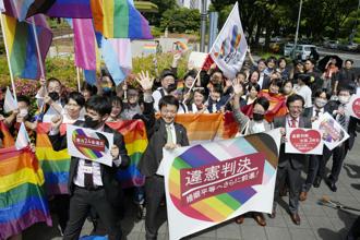 2023年5月30日，在日本名古屋地方法院外，下級法院裁定不允許同性婚姻違憲後，包括原告律師在內的人們舉著橫幅和旗幟資料照。（路透社）