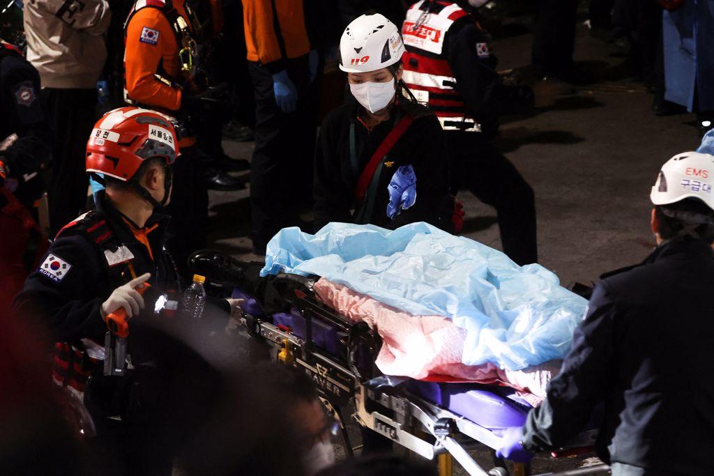 2022年10月29日，韓國首爾萬聖節期間發生踩踏事件，救援人員在現場搬運一具屍體，造成數十人受傷資料照。（路透社）