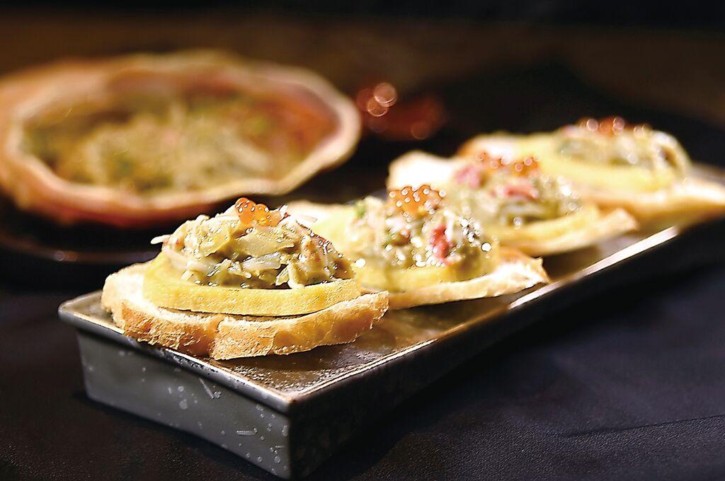 〈松葉蟹甲羅燒〉是將蟹味噌和蟹肉放置蟹殼燒烤，最後放在切片法國麵包上呈現。圖／姚舜