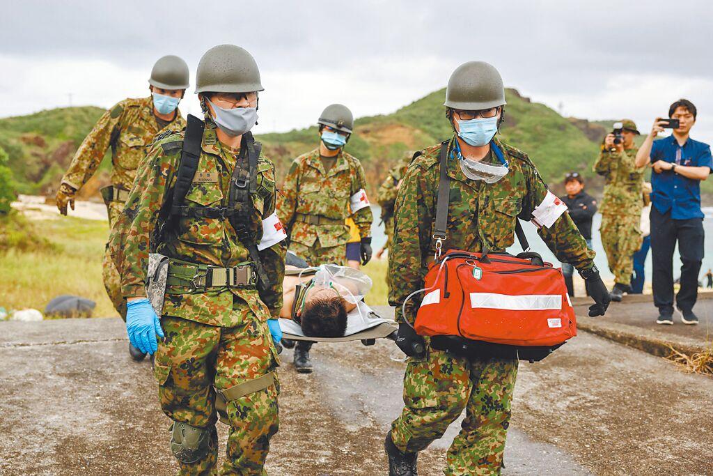 為因應「台灣有事」，日本正研擬沖繩縣居民疏散計畫。圖為日本自衛隊員，在沖繩縣與那國島的海灘進行疏散演習。（路透社）