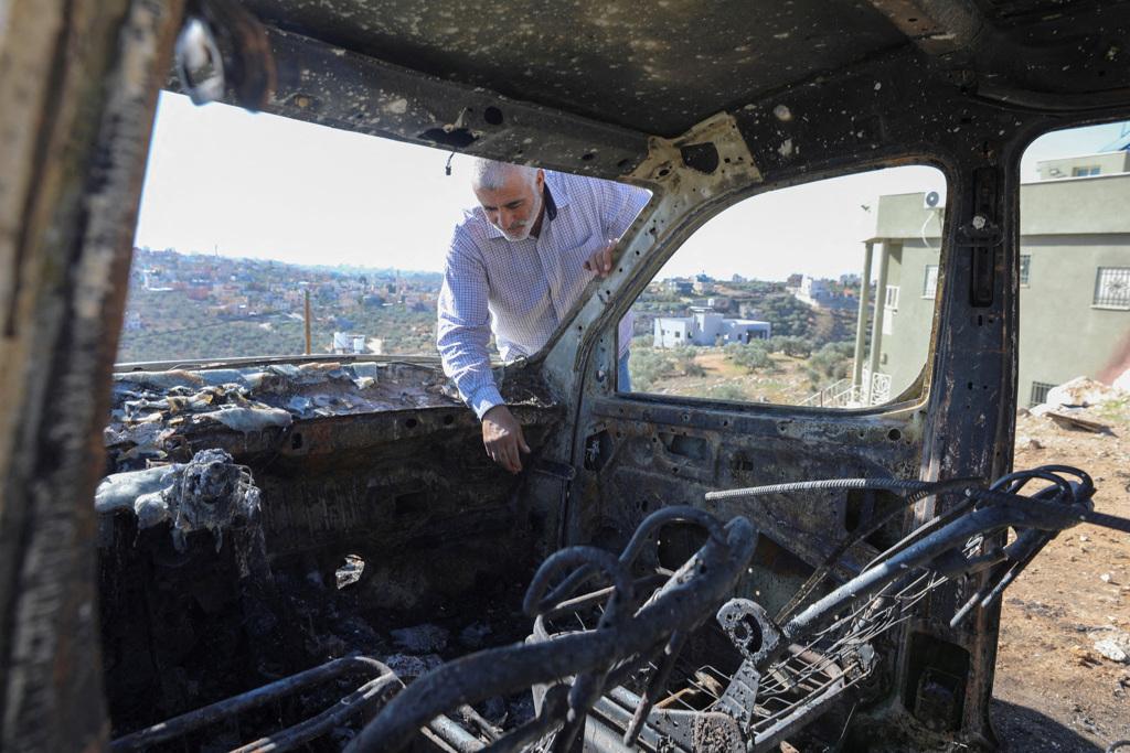 美國將拒絕核發簽證給攻擊巴勒斯坦人的激進以色列屯墾者，為遏止約旦河西岸爆發的暴力事件。圖為巴勒斯坦居民查看遭以色列屯墾者放火燒毀的車輛。（圖／路透社）