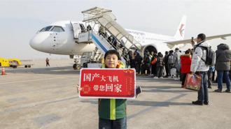大陸國產C919春運首秀執行10個航班承運1274名旅客。圖為1月26日上海虹橋機場小旅客手舉標語牌在C919前合影。 （新華社）